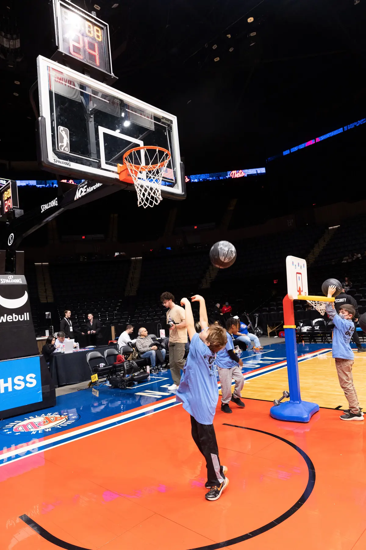 A young player shooting at a pro arena hoop
